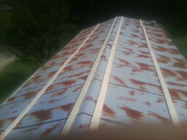 Rusted metal roof panels with new wood purlins before replacement — Storm Damage Roof Repair in Joffre by Roofing Brothers