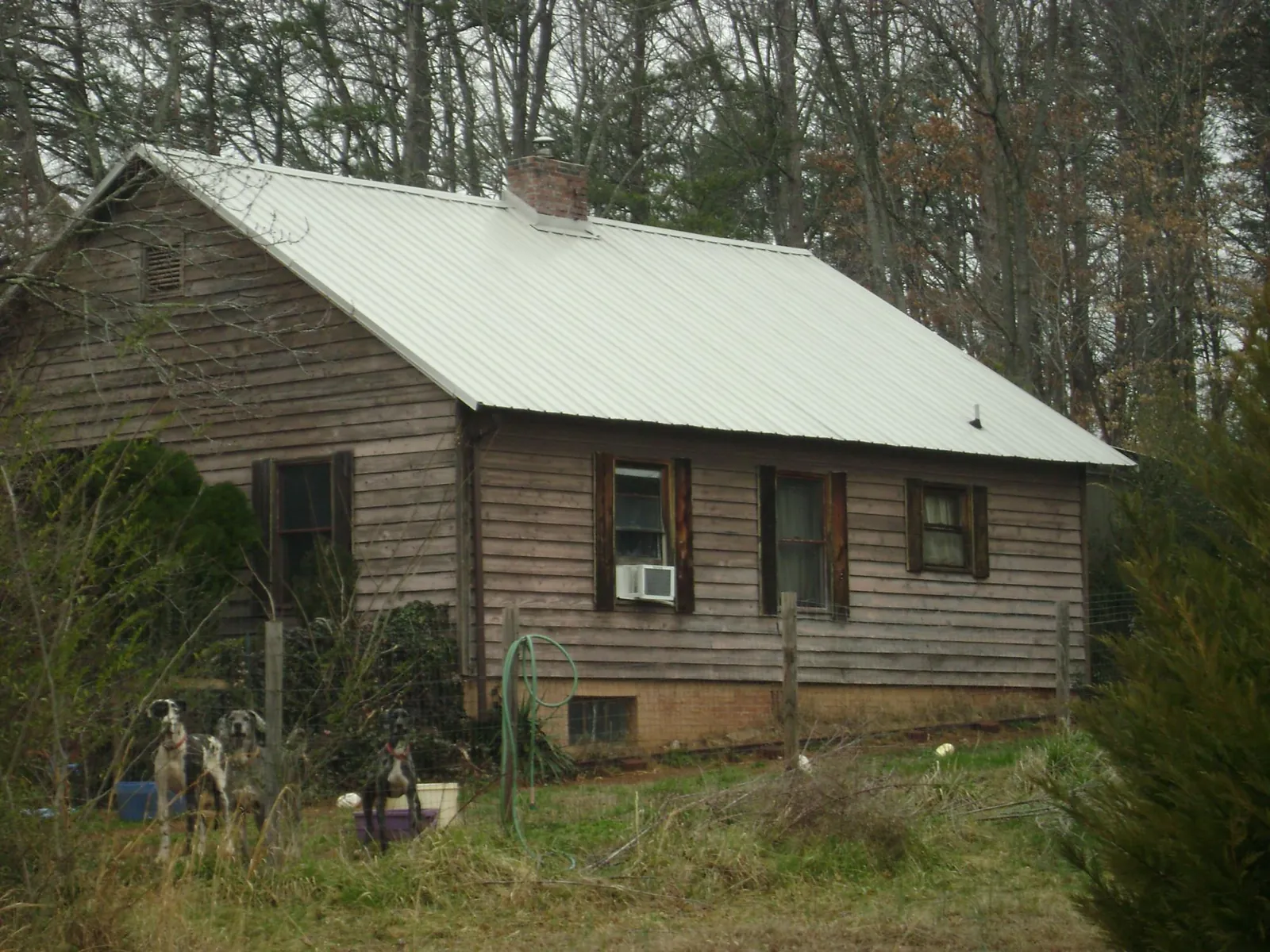White metal roof on an old wood sided farmhouse, from a Metal Roof Installation job in Joffre