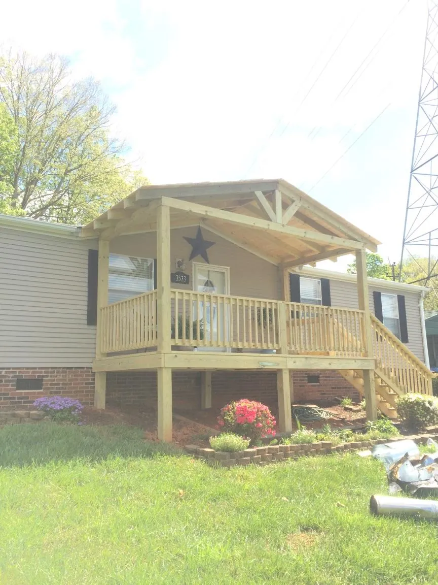 New gabled porch roof and deck railing added to a ranch home in Joffre